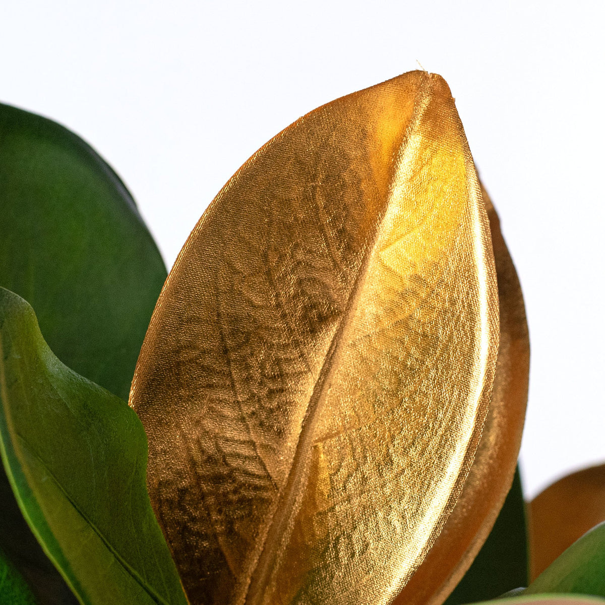16" Artificial Magnolia Leaves Stem: Green & Metallic Gold Lifestyle Photo